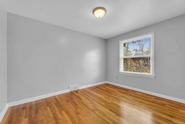 unfurnished room featuring baseboards, visible vents, and light wood-style floors