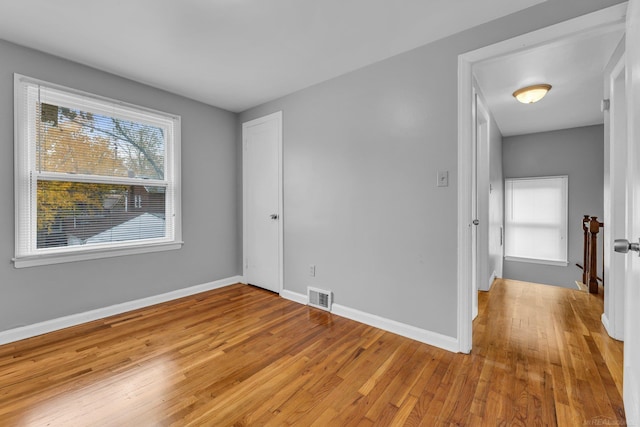 unfurnished bedroom with light wood-style floors, visible vents, and baseboards