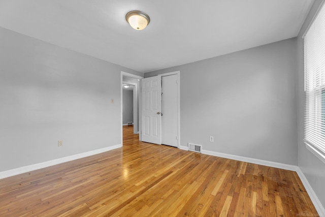 unfurnished bedroom featuring light wood finished floors, visible vents, and baseboards