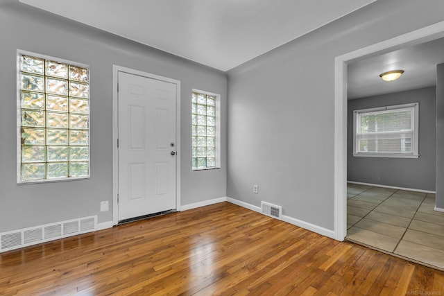 foyer entrance featuring wood-type flooring, visible vents, and baseboards