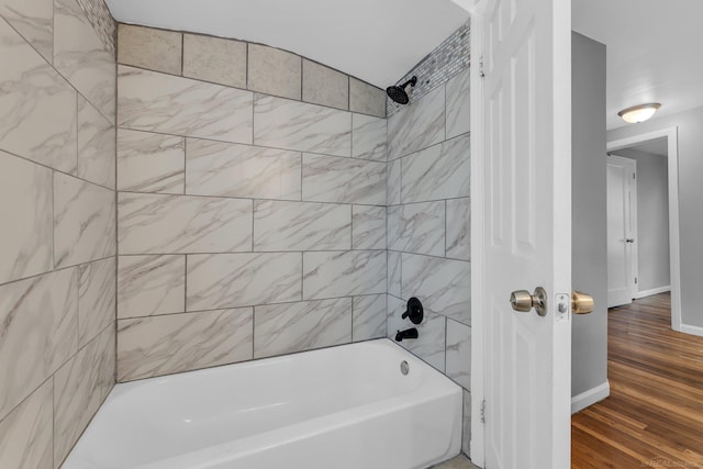 full bathroom featuring bathtub / shower combination, baseboards, and wood finished floors