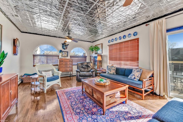 living room featuring an ornate ceiling, ceiling fan, and wood finished floors