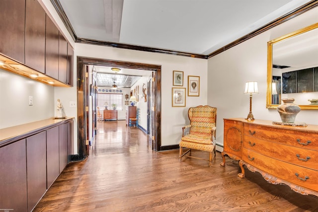 interior space with ornamental molding, baseboards, baseboard heating, and wood finished floors