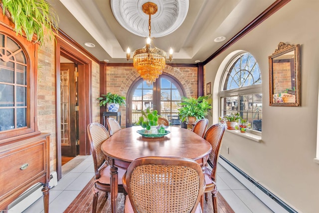 dining area with light tile patterned floors, a baseboard radiator, a notable chandelier, brick wall, and a raised ceiling