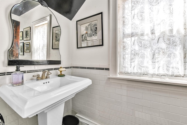 bathroom featuring a wainscoted wall, a sink, and tile walls