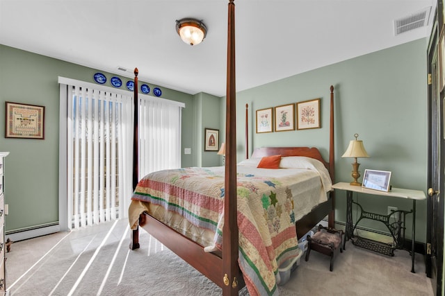 carpeted bedroom featuring a baseboard heating unit and visible vents