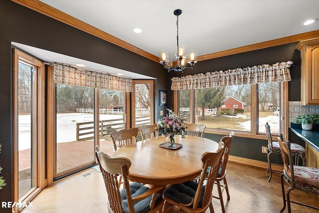 dining area featuring baseboards, ornamental molding, a chandelier, and recessed lighting