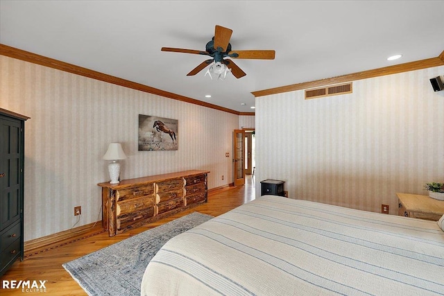 bedroom featuring wallpapered walls, visible vents, light wood-style floors, and crown molding