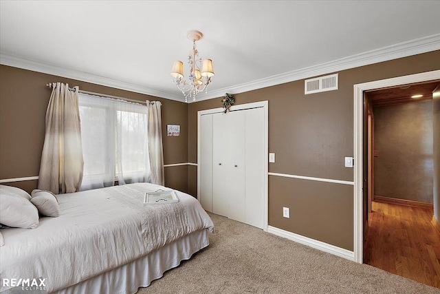 bedroom with baseboards, visible vents, ornamental molding, an inviting chandelier, and a closet