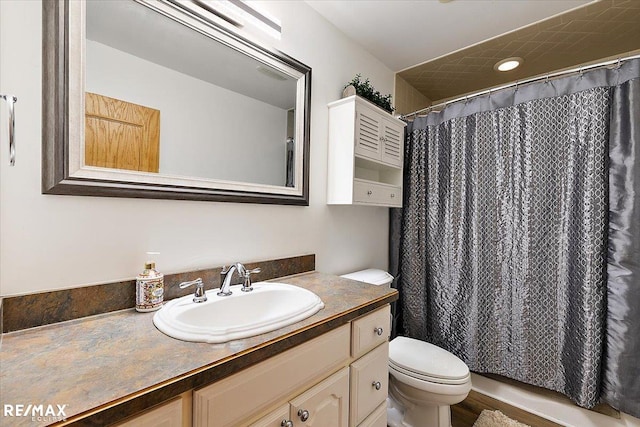 bathroom with toilet, a shower with shower curtain, and vanity