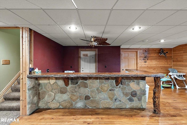 bar with recessed lighting, stairway, ceiling fan, wooden walls, and wood finished floors