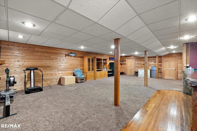 exercise area with carpet flooring and wooden walls