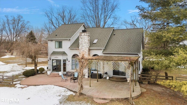 back of house featuring a shingled roof, a chimney, fence, and a patio