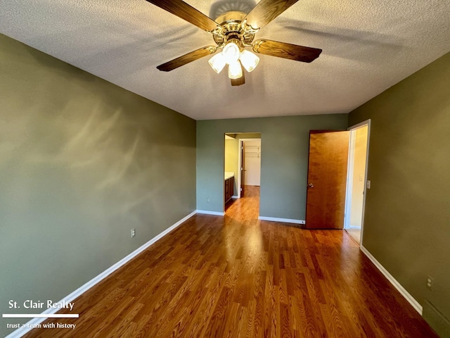 unfurnished bedroom with a ceiling fan, a textured ceiling, baseboards, and wood finished floors