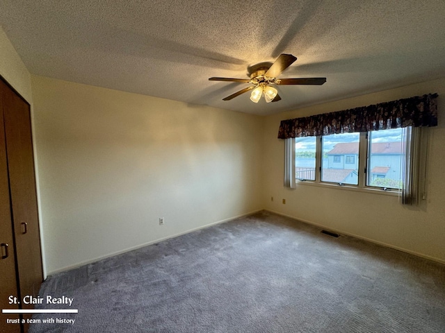 spare room featuring baseboards, a textured ceiling, visible vents, and a ceiling fan