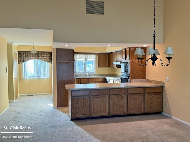 kitchen with a wealth of natural light, light colored carpet, and visible vents