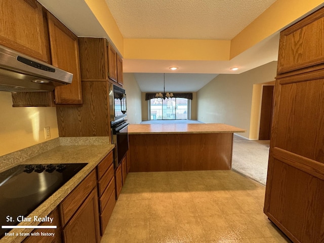 kitchen featuring black appliances, brown cabinetry, a peninsula, and exhaust hood