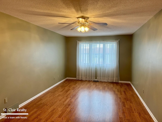 unfurnished room with a ceiling fan, a textured ceiling, baseboards, and wood finished floors