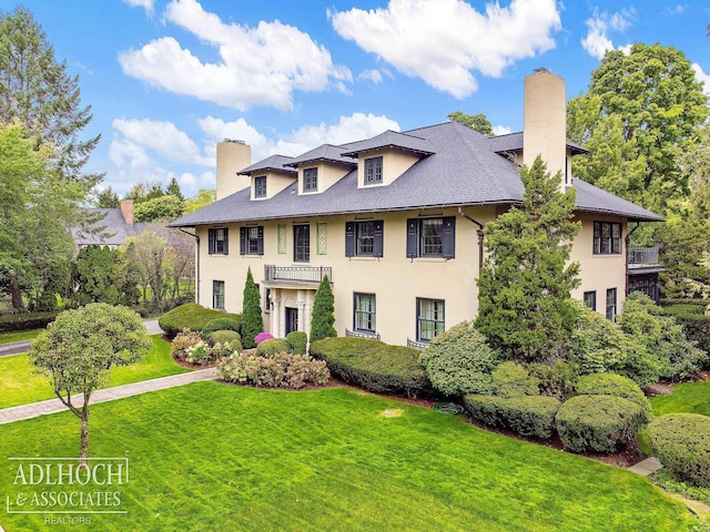 colonial-style house with a chimney and a front yard