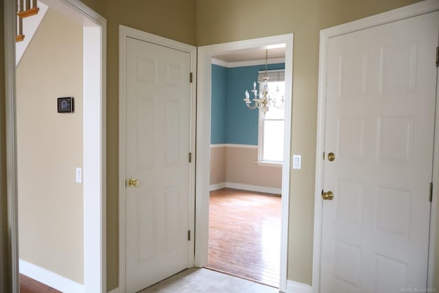 entrance foyer featuring baseboards, stairs, and a notable chandelier