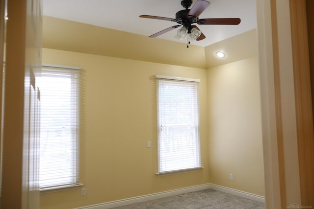 carpeted spare room with ceiling fan and baseboards