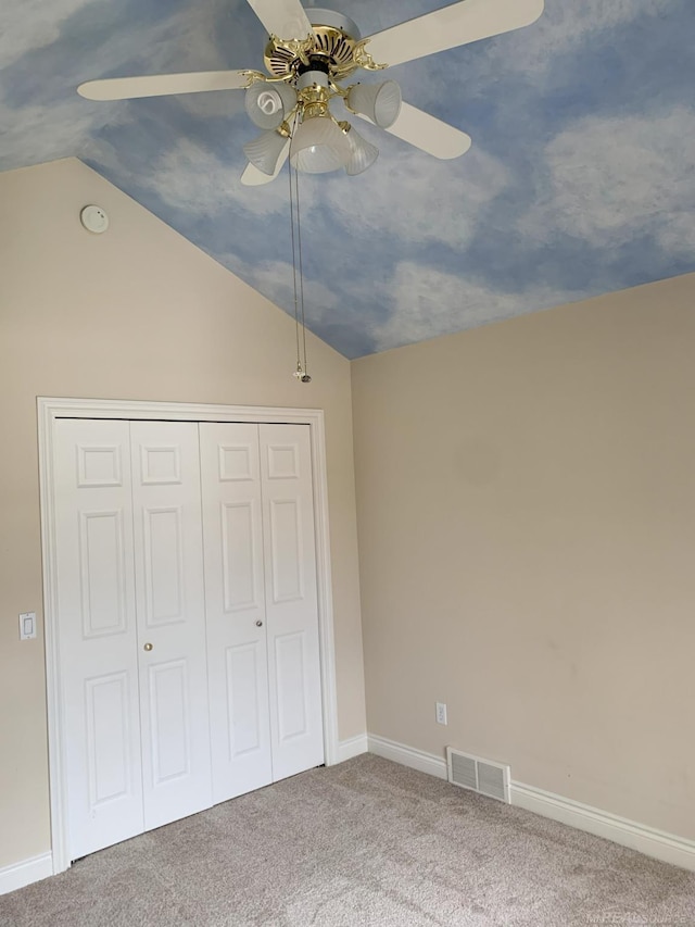 unfurnished bedroom with carpet, a closet, visible vents, and vaulted ceiling