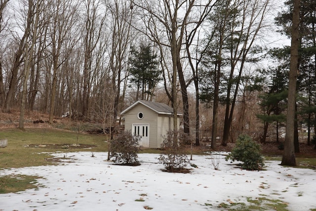 snowy yard featuring an outbuilding