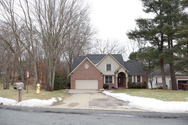 traditional-style home with a garage, concrete driveway, brick siding, and a front yard