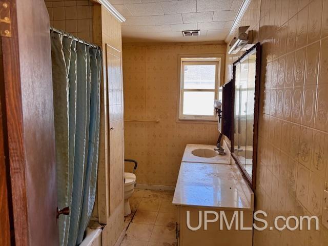 full bathroom featuring shower / bath combination with curtain, visible vents, toilet, vanity, and tile patterned floors