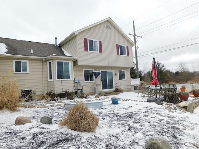 snow covered house featuring cooling unit