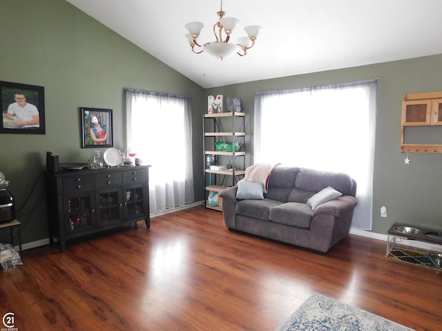 living area with lofted ceiling, baseboards, wood finished floors, and a notable chandelier