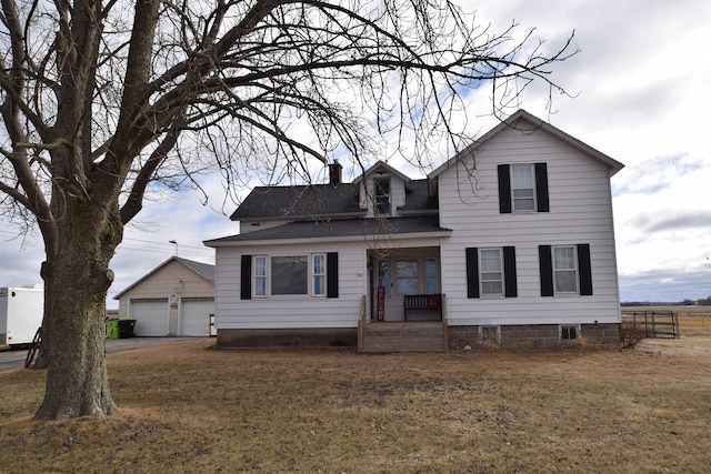 view of front of home featuring an outbuilding, roof with shingles, a chimney, a front yard, and a garage