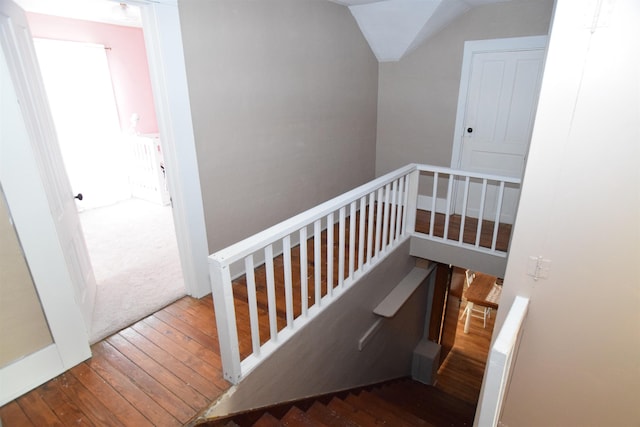 stairway with lofted ceiling and hardwood / wood-style flooring