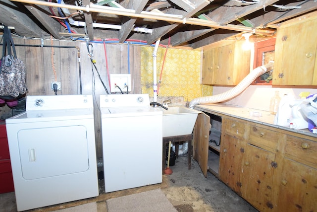 laundry area with laundry area, separate washer and dryer, and a sink