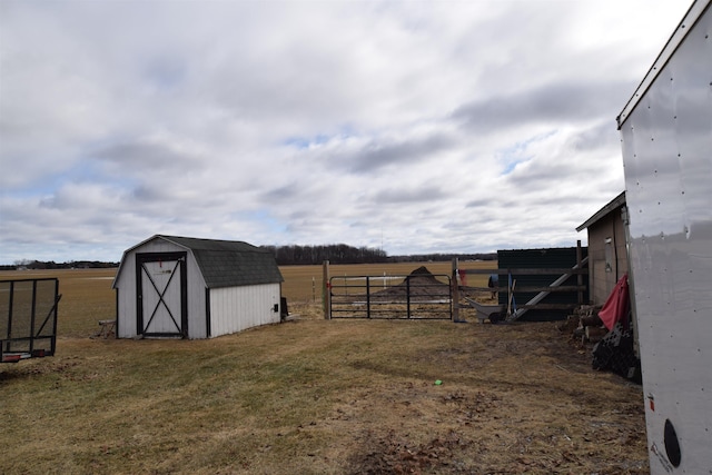 view of shed with a rural view and fence