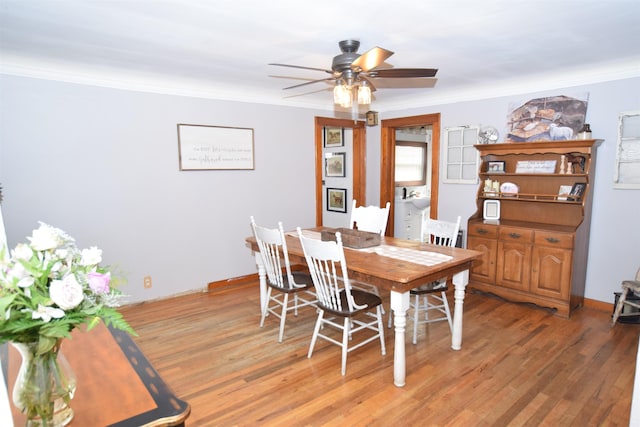 dining area featuring light wood-style floors, crown molding, and a ceiling fan