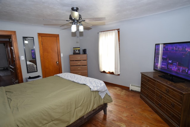 bedroom with hardwood / wood-style flooring, ceiling fan, baseboards, and baseboard heating