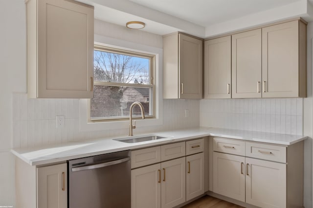 kitchen with a sink, light countertops, cream cabinetry, dishwasher, and tasteful backsplash