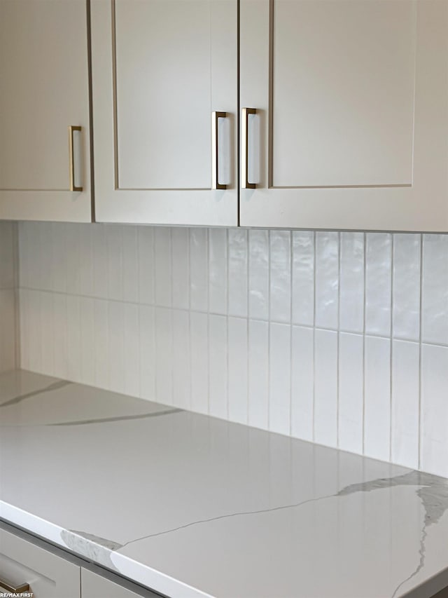 room details with light stone countertops and gray cabinets