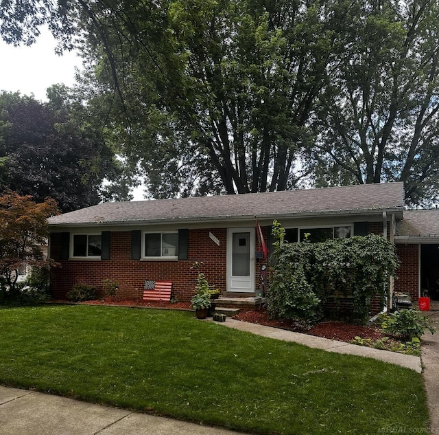 ranch-style house featuring a front lawn and brick siding