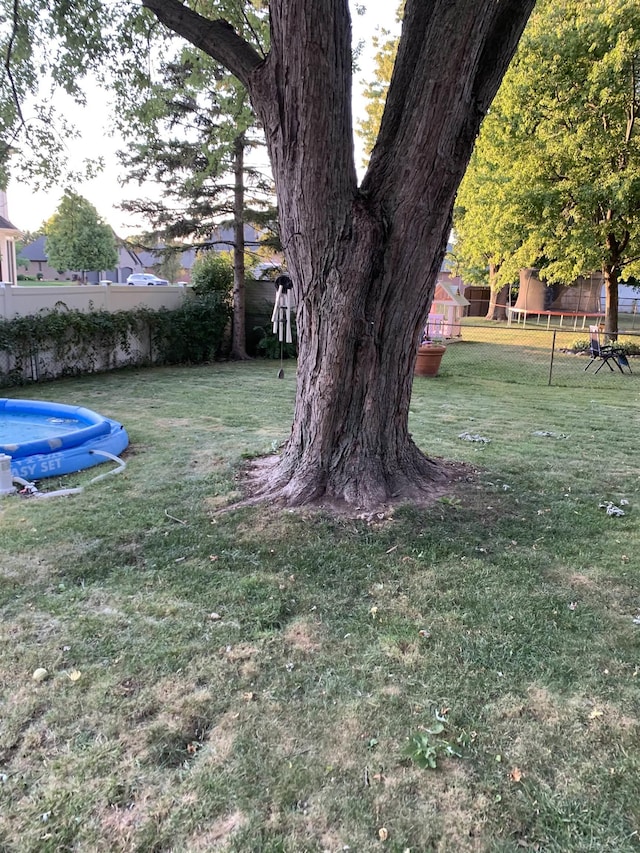 view of yard with fence and a pool