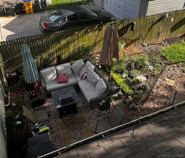 exterior space featuring an outdoor hangout area, a patio, fence, and a garage