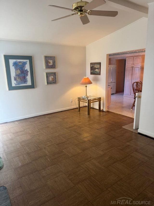 empty room with lofted ceiling with beams, ceiling fan, and baseboards