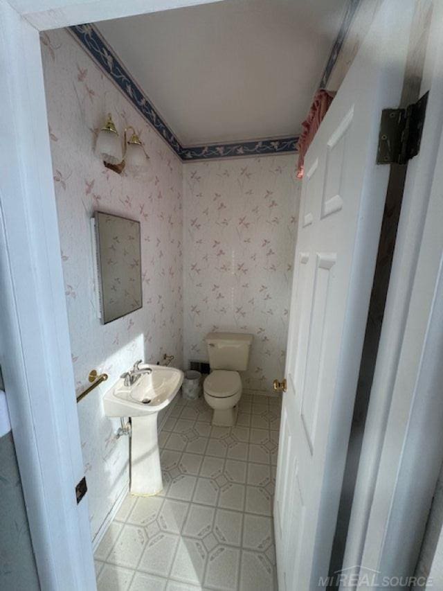 bathroom featuring toilet and wallpapered walls