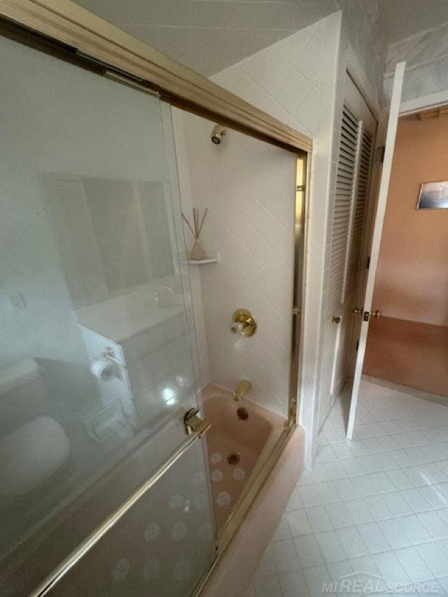 full bathroom with bath / shower combo with glass door and tile patterned floors