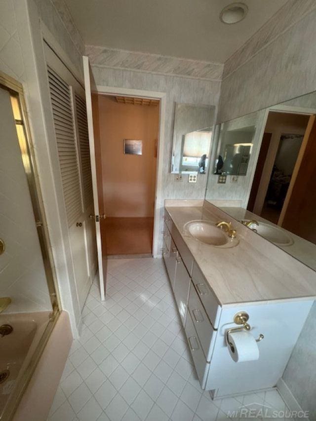 bathroom with tile patterned flooring, bathtub / shower combination, tile walls, and vanity