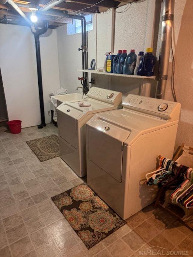 laundry room with laundry area, light floors, a sink, and washing machine and clothes dryer