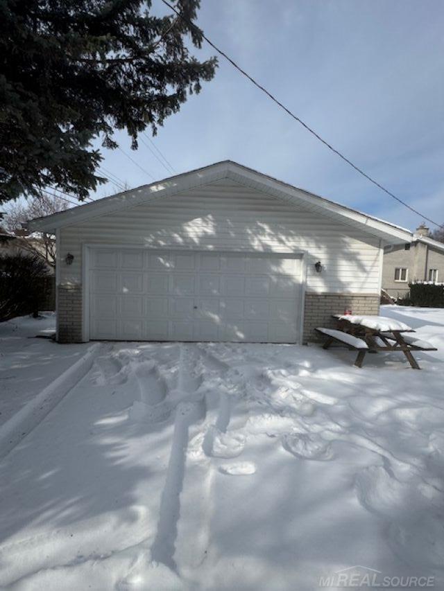 snow covered garage featuring a garage