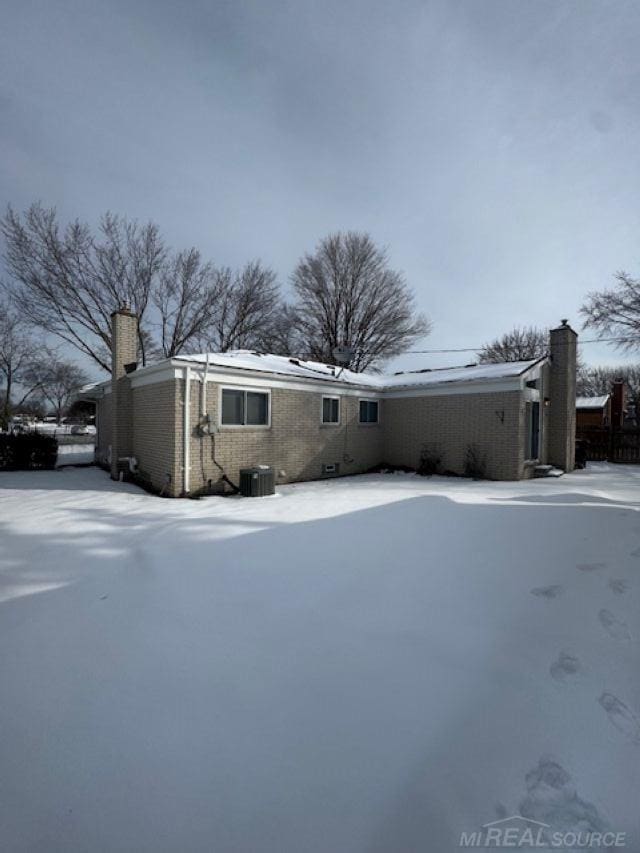 exterior space with a chimney and cooling unit