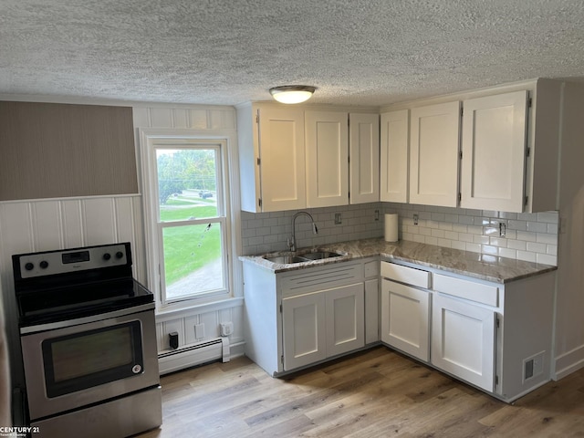 kitchen featuring light wood-style flooring, a sink, visible vents, electric stove, and baseboard heating